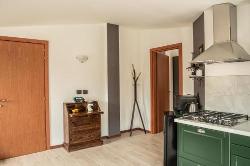 a kitchen with green cabinets and a stove top oven at Appartamenti Edolo - A 20 minuti da Ponte di Legno e Aprica in Edolo