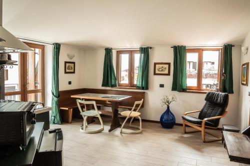 a living room with a table and chairs at Appartamenti Edolo - A 20 minuti da Ponte di Legno e Aprica in Edolo