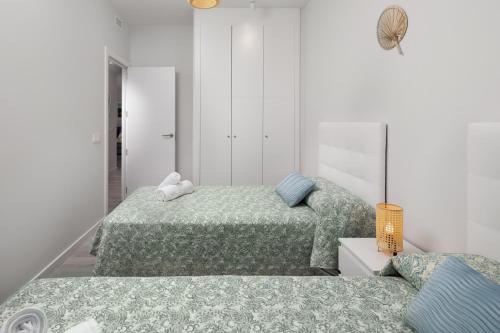Residencial Celere Playa Niza في ألماياتيه باخو: سريرين في غرفة بيضاء مع سريرين sidx sidx