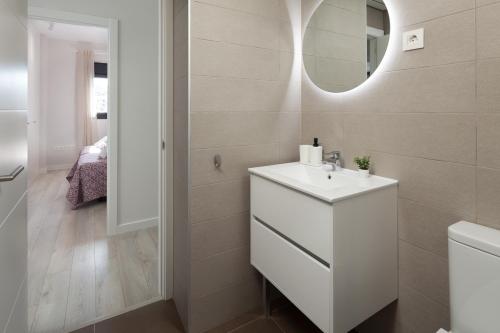 La salle de bains est pourvue d'un lavabo blanc et d'un miroir. dans l'établissement Residencial Celere Playa Niza, à Almayate
