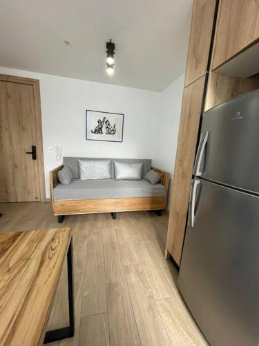 a living room with a couch and a refrigerator at Lindo e iluminado apartaestudio en La Carolina in Quito