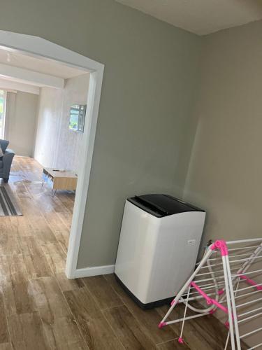 a living room with a white wall and a chair at 2Bedroom Vacation Home in Paix Bouche