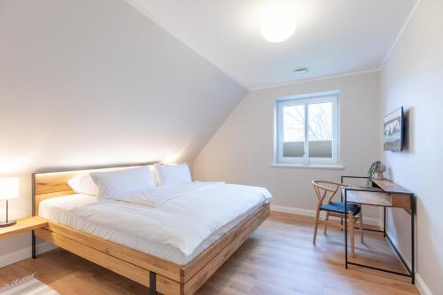 Un dormitorio con una cama, un escritorio y una silla. en Biikehuus West, en Niebüll