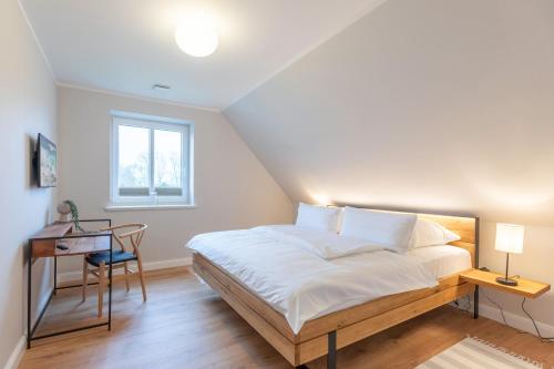 Un dormitorio con una cama y un escritorio y una ventana. en Biikehuus Ost, en Niebüll