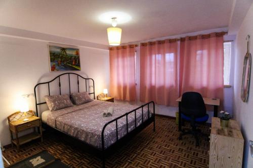 a bedroom with a bed with pink curtains and a desk at Nomad Villa Santa Fe in Las Palmas de Gran Canaria
