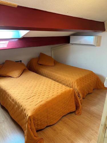 deux lits côte à côte dans une pièce dans l'établissement Holidayland Résidence Beau Soleil villa avec piscine, à Narbonne-Plage