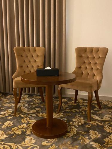 a table and two chairs in a room at فندق بلفيو بارك رويال Bellevue Park Royal Hotel in Taif