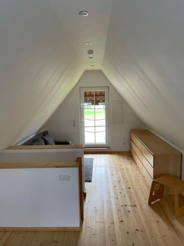 een zolderkamer met een bed en een raam bij Ferienhaus Waldweg in Wienhausen