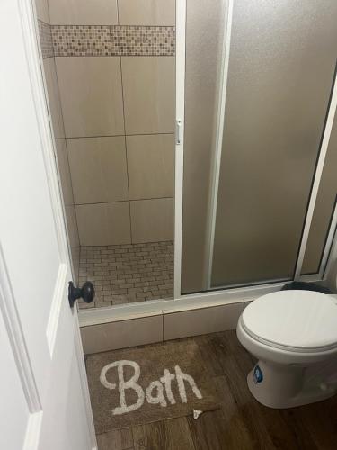 a bathroom with a shower and a toilet with the word bath on the floor at 2Bedroom Vacation Home in Paix Bouche