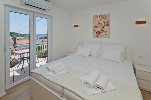 a bedroom with a white bed and a balcony at Luka's Lodge Guesthouse & Hostel in Hvar
