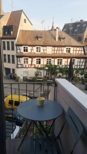 uma mesa e cadeiras numa varanda com vista para os edifícios em Magnifique appartement em Estrasburgo