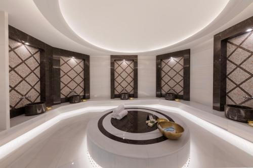 Hallmark Hotel & SPA Istanbul في إسطنبول: غرفة كبيرة مع حوض استحمام كبير ونوافذ