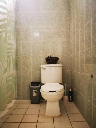 a bathroom with a toilet with a basket on top of it at Panoramic Paradise 5 min to downtown and beach in Zihuatanejo