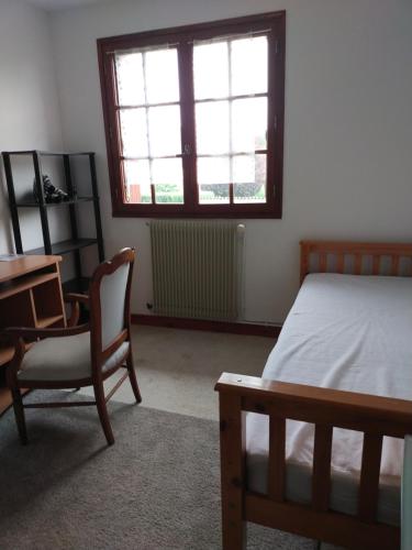 a bedroom with a bed and a desk and a chair at Gîte La vie au vert Spacieux et autonome in Malay-le-Grand