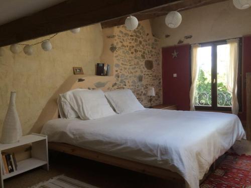 a bedroom with a large white bed and a window at The Piggery, charming converted stone gite in Saint-Mesmin