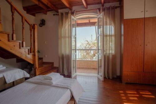 a bedroom with two beds and a large window at Kohyli House in Agia Pelagia Chlomou
