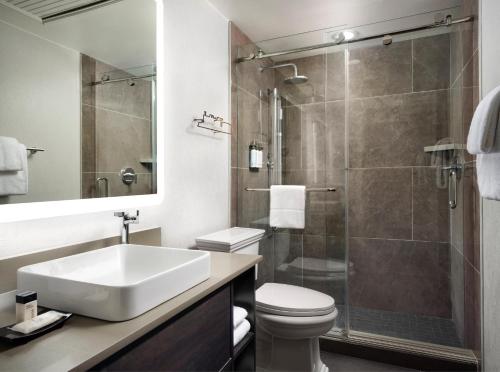 a bathroom with a toilet and a sink and a shower at The Union Station Nashville Yards, Autograph Collection in Nashville