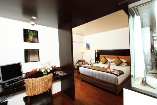 a hotel room with a bed and a desk with a computer at Iris The Business Hotel in Bengaluru