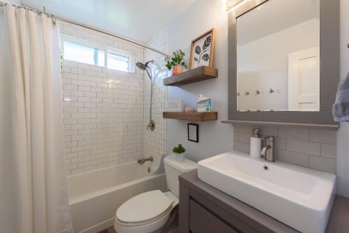 a bathroom with a sink and a toilet and a mirror at YellowDoorBeachHouse close to Moonlight Beach and LEGO Land in Encinitas