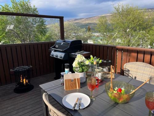 a picnic table on a deck with a grill at Charming 3 bedroom apartment in Akureyri