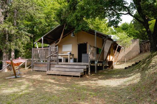 una casa con porche y escaleras delante en Glamping Siena en Siena