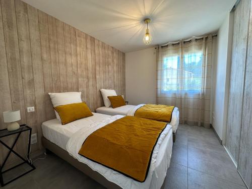 une chambre avec deux lits et une fenêtre dans l'établissement Villa Sarlat ,piscine/jacuzzi, à Saint-Vincent-le-Paluel