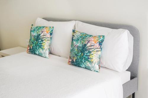 two pillows on a bed with white sheets at Casa da Avó Toninha by Quantique in Braga