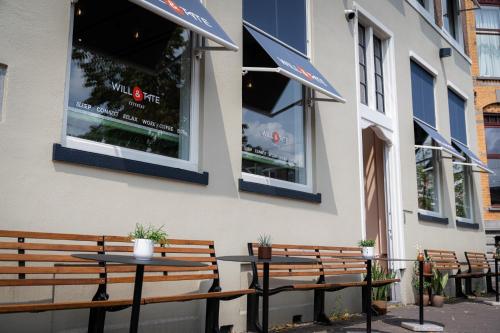 a couple of benches and tables outside of a building at The Monument Hotel in The Hague