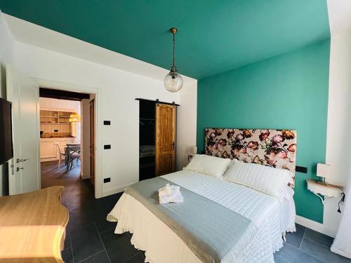 a bedroom with a large bed with a blue wall at Locanda alla Grotta in Crone