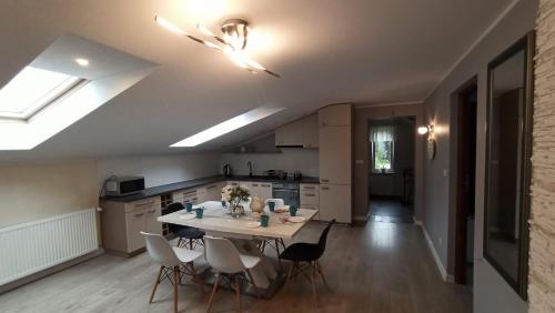 uma cozinha com mesa e cadeiras num quarto em Apartament "Na szlaku" em Ostrowo