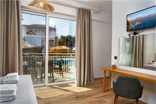 a room with a view of the pool and a desk and chair at Amoudi Studios Apartments Hotel in Amoudi