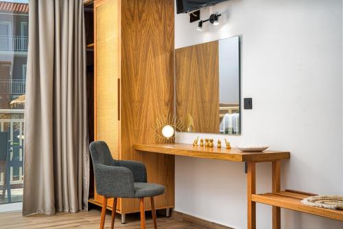 a bathroom with a sink and a chair and a mirror at Amoudi Studios Apartments Hotel in Amoudi