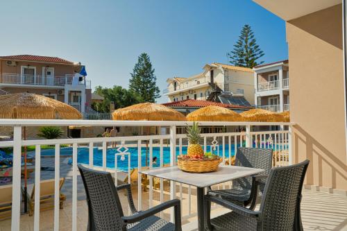 a table and chairs on a balcony next to a pool at Amoudi Studios Apartments Hotel in Amoudi