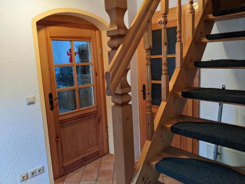 a staircase with a wooden door and a window at Ferienhaus 3 Eulen in Kurort Altenberg