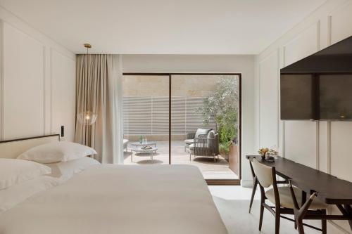 a bedroom with a bed and a desk and a chair at Theatron Jerusalem Hotel & Spa MGallery Collection in Jerusalem