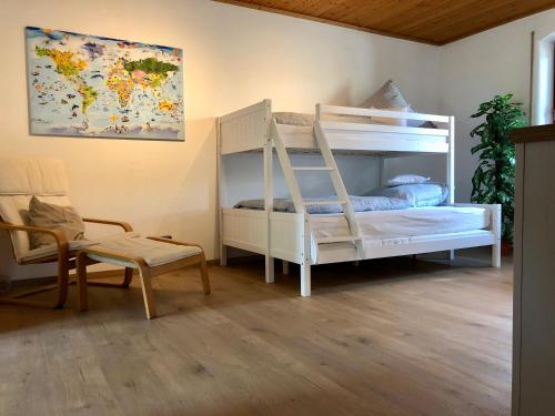 a bedroom with a white bunk bed and a chair at Altmühl Familienvilla in Treuchtlingen