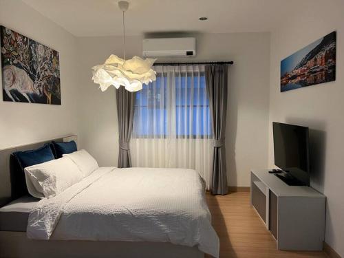 a bedroom with a bed and a flat screen tv at MOST Family 456/66 Ubon-Thailand in Ubon Ratchathani