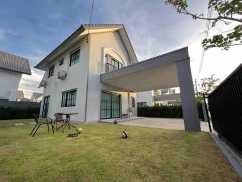 a house with a yard with a soccer ball on the grass at MOST Family 456/66 Ubon-Thailand in Ubon Ratchathani