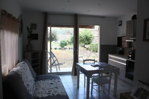 a living room with a couch and a table and a kitchen at A CARDICCIA Loc saisonnières PIANA in Piana