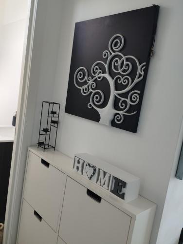 a painting of a tree on a wall above a dresser at Ca Na Xisca in Felanitx
