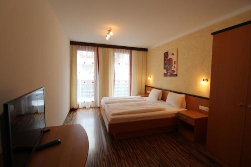 ein Hotelzimmer mit einem Bett und einem TV in der Unterkunft Apartment Lamtana in Ischgl