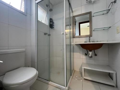 a bathroom with a toilet and a sink and a shower at Lindo ap dentro da riviera mód 8 pertinho da praia área de lazer completa in Riviera de São Lourenço