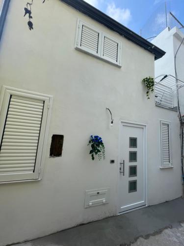 een wit huis met twee ramen en een deur bij gler_house in Ischia