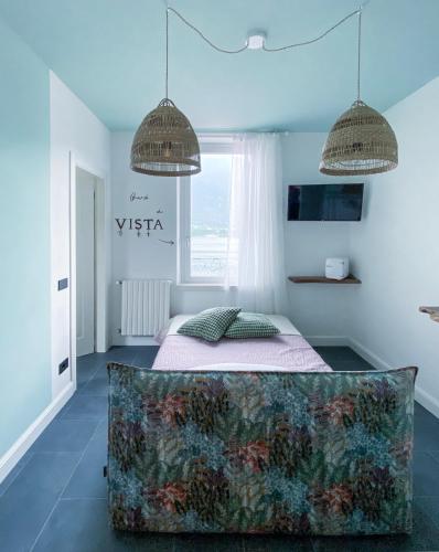 a bedroom with a bed and two pendant lights at Locanda alla Grotta in Crone