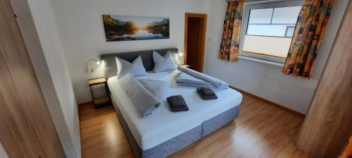 1 dormitorio con cama blanca y ventana en Apart MARO, en Längenfeld