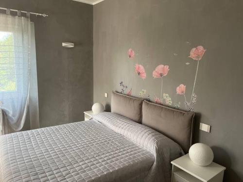 ein Schlafzimmer mit einem Bett mit rosa Blumen an der Wand in der Unterkunft Al Buffardel in Bagnone