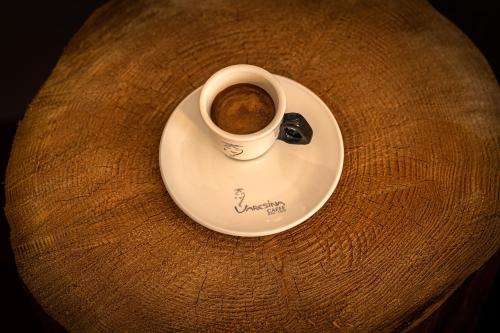 a cup of coffee on a plate on a table at Hotel i Restauracja Czarny Kos in Borkowo