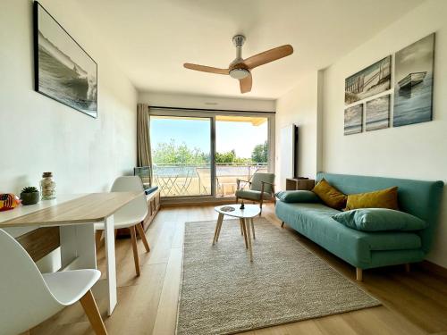 un soggiorno con divano blu e tavolo di T2 refait à neuf – À 2 pas du bourg et des plages a Larmor-Plage