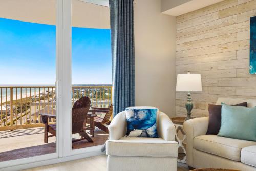 a living room with a view of a balcony at Calypso Tower 3 - Endless Sunsets and Gulf Coast View! in Panama City Beach