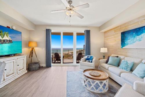 a living room with a couch and a tv at Calypso Tower 3 - Endless Sunsets and Gulf Coast View! in Panama City Beach